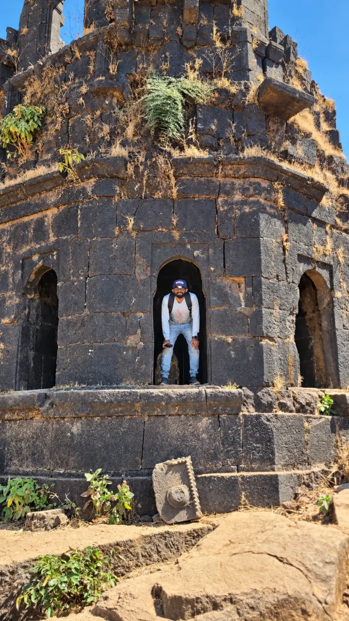 Terry sitting alone in a stone doorway at a basalt fort in Mahad, Maharashtra